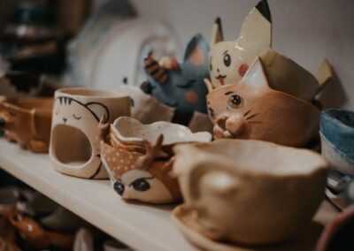 Charming collection of animal-faced ceramic cups on a shelf, capturing creative and artistic vibes.